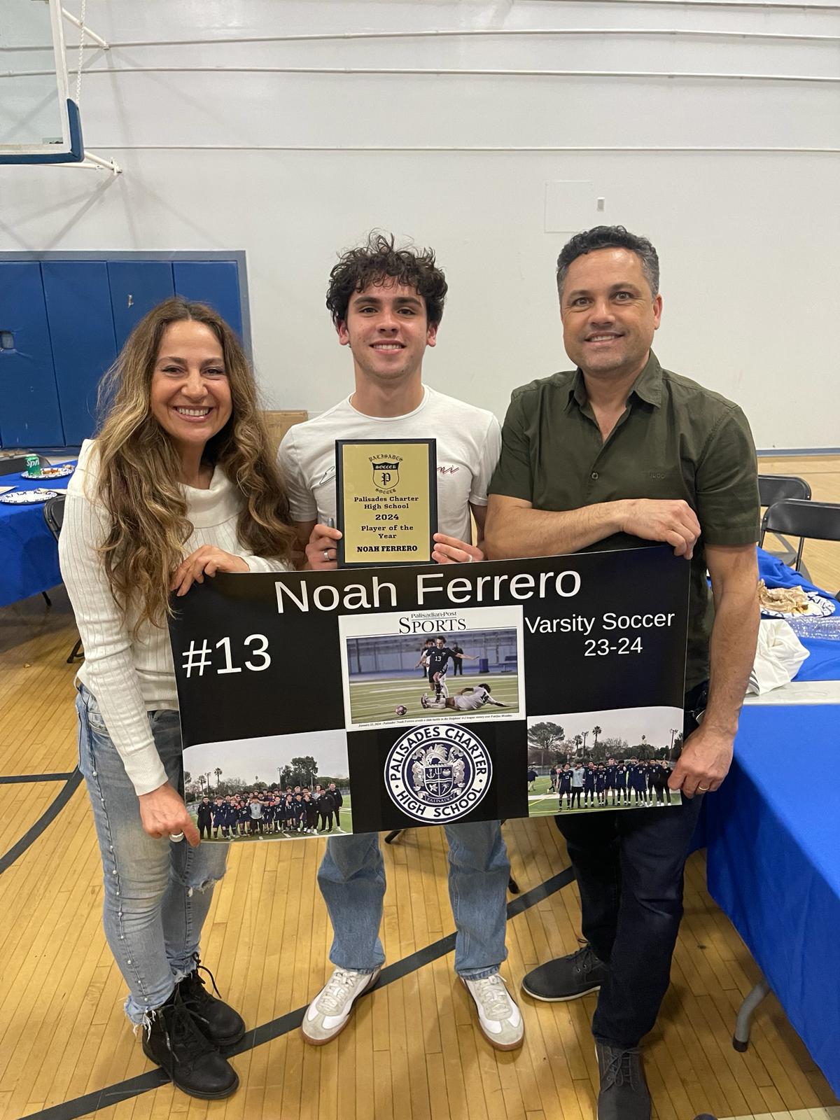 Coach Noah holding his Player of the Year award with his parents beside him